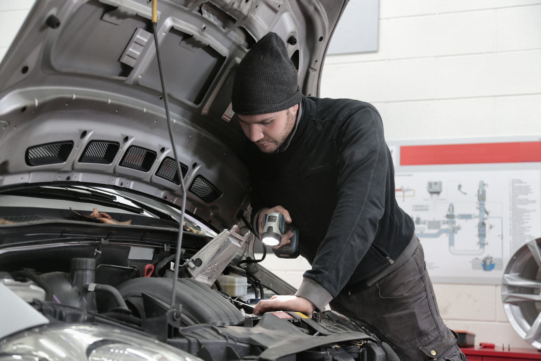 Technician inspecting vehicle components in a workshop