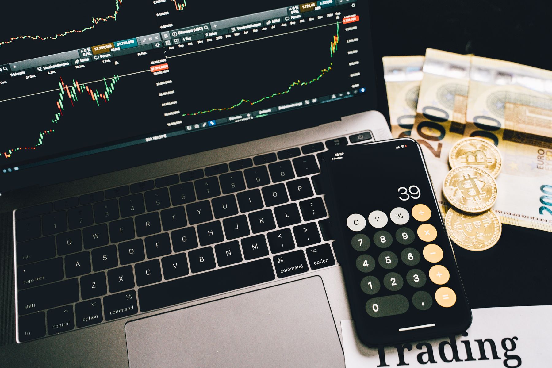 Trading workstation with laptop charts, Bitcoin coins and calculator